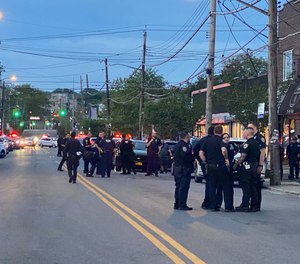 Police gather at the scene where an EMT was shot in Staten Island on Thursday evening.