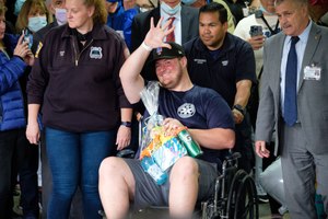 EMT Richard McMahon, who was shot by a patient in May, waves to supporters as he is released from Richmond University Medical Center.