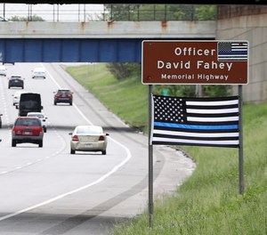 A Thin Blue Line flag hangs below the ODOT sign honoring fallen Cleveland police officer David Fahey, who was killed in the line of duty along this stretch of I-90.
