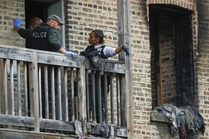 Chicago police investigate at the scene of a fire that killed a 2-year-old child in a second-floor apartment on May 24, 2022.