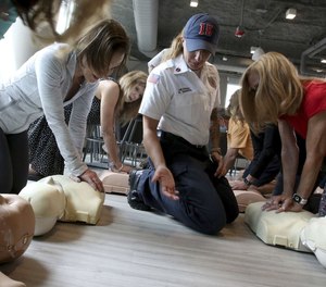 Lincolnwood Fire Department Lt. Gabby DeSanta teaches CPR to employees of the Levin & Perconti law firm in Chicago on May 31.