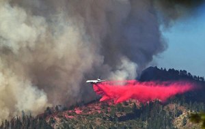A plane drops fire retardant as the Washburn Fire burns near the Mariposa Grove of giant sequoias and the south entrance of Yosemite National Park on July 11.