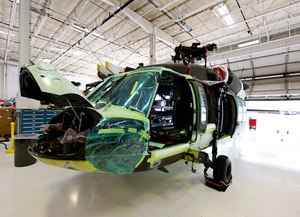 The chopper is undergoing a transformation, one from matte military utility to red, white and blue, with a water-filled gut and unique firefighting capabilities. It is turning from Black Hawk to Firehawk.