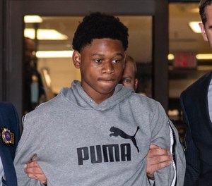 Oshawn Logan, 18, is escorted from the NYPD's 43rd Precinct stationhouse in the Bronx, on Friday, Aug. 26, 2022.