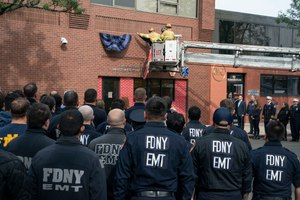 FDNY members assemble while bunting is placed at EMS Station 49 Friday in Queens.