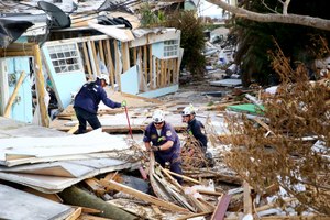Anthony Prado (left) Bryan Bartlett and Angel Menendez, with the South Florida Urban Search and Rescue Team, work together on Oct. 5 to search for people in homes damaged by Hurricane Ian.