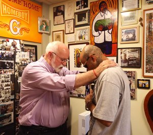 Robert Trejo, 32, right, receives a blessing from Father Greg Boyle, founder and director of Homeboy Industries. For over 30 years Homeboy Industries has offered programs to assist high-risk youth, former gang members and the recently incarcerated.