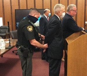 Ex-Cuyahoga County Jail Director Ken Mills is handcuffed after a judge sentenced him to nine months in jail.