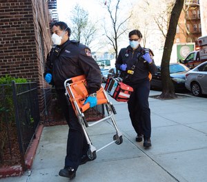 FDNY Paramedic Chris Feliciano, 38, and Kim Benson, 41 carry equipment out of an ambulance outside the home of a Covid-19 patient in Queens, New York. Tuesday May 5th, 2020.