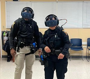 New London police officers Daquan Stuckey (left) and Christina Nocito participate in a training simulation using the department's new Apex Officer virtual reality system.