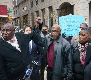 Christopher Williams, center, is seen in a December 2021 photograph, after announcing a lawsuit against the city of Philadelphia, police, and prosecutors.