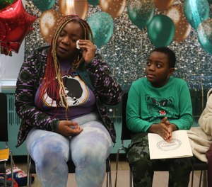Geneva Davis wipes away a tear as Boston Firefighter Local 718 honors her son, 8-year-old Hasani Little, for helping to save his family from a fire. Her son was honored during an event at the Shaw Elementary School on Monday.