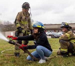 Joselin Barrera, student of Bryan Station High School, sprays a fire hose during the Brenda Cowan Camp with the assistance of firefighters Sarah McGill, center, and Megan Morrell, right. Lexington fire department hosted the Brenda Cowan Camp Nov. 16, 2022, for girls ages 16 to 25 in remembrance of Brenda Cowan, Lexington s first Black female firefighter, who was killed in the line of duty on February 13, 2004.