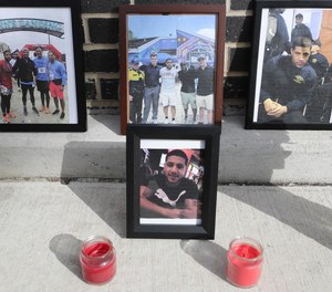 Photos of Temple University Police Officer Christopher Fitzgerald line a memorial that was created near where he was shot to death Saturday night.