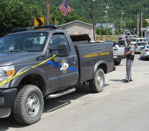 Kentucky State Police blocked off a street in Allen, a small town in Floyd County, Ky., on July 1, 2022 as the investigation continued into a shooting in which two police officers were killed.