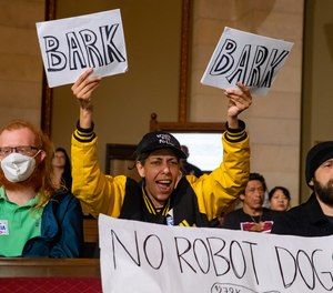 An audience member voices her opposition to the donation of a robot dog.