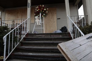 A stuffed bear is at the door of a fire-damaged home in Chicago, where a woman and three children suffered smoke inhalation during a fire on the night before.