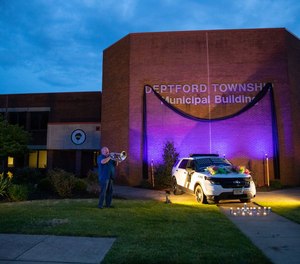 Bert Fox, of Deptford, plays taps next of fallen police Officer Robert Shisler's patrol car at the Deptford Police station in Deptford, NJ on Sunday, May 7, 2023. Fox came on his own volition saying, 