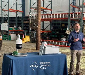 At a Wednesday press event, Brett Phillips, manager of the Wildfire Operations Program at Portland General Electric, shows the utility companys new panoramic AI-enhanced cameras (left, on table) and the \