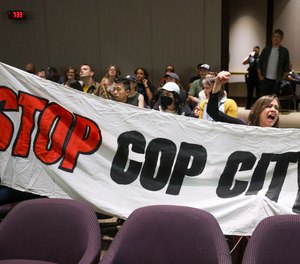 Protestors hold a banner and shout, Stop Cop City, during the public comment portion of the Atlanta City Council ahead of the final vote to approve legislation to fund the training center at Atlanta City Hall, on Monday, June 5, 2023, in Atlanta.