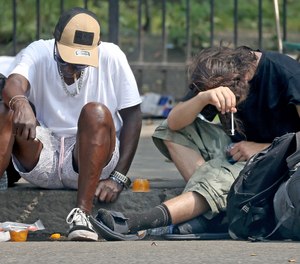 A man holds a syringe on Southampton Street Monday near the epicenter of Boston's opioid crisis, Mass and Cass.