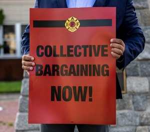 Portsmouth Professional Firefighters & Paramedics IAFF Local 539 President Lt. Kurt Detrick holds an IAFF, International Association of Firefighters, collective bargaining sign outside of Portsmouth Fire Station 1 on Friday, July 28, 2023.
