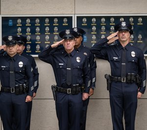 Officers salute during the playing of the National Anthem during a ceremony at LAPD Headquarters in Los Angeles.
