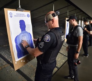 Westminster police officers, including Sgt. Bill Drinnin, left, check their accuracy with live ammunition at an indoor shooting range.
