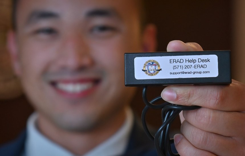 Westminster PD Fraud and Financial Crimes Detective Henry Tran shows the department's new electronic tool that allows investigators check balances and freeze prepaid debit cards of potential criminal funds while still out in the field.
