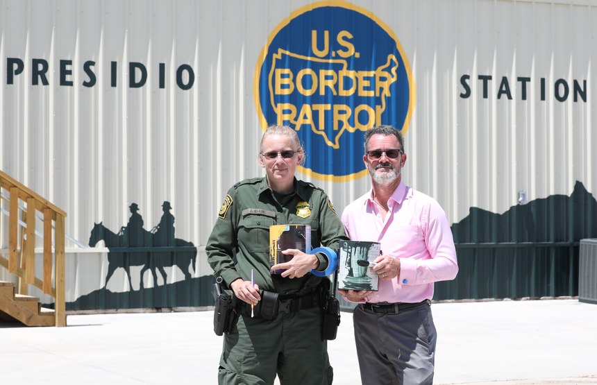 Border Patrol Watch Commander Janenne Ellis and her husband, Steven, pose in front of a mural at the Presidio Border Patrol Station in Presidio, Texas.