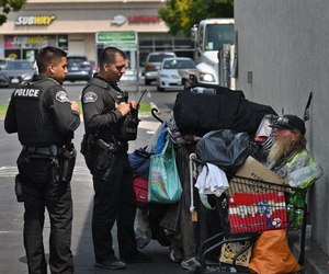 Fullerton PD Homeless Liaison Officers Max Raj and Bryan Franco talk to Terry, a homeless man, about getting him into a shelter.