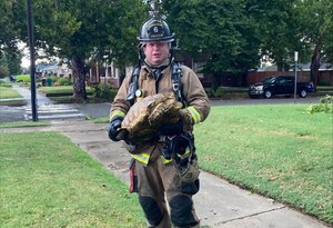Firefighter Aaron Dickson posed for a photo with the large tortoise.