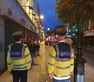 Two police officers with An Garda Síochána, Ireland's national police force, walk their beat.