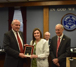 Sheriff Terry Johnson and Board of Commissioner Chair John Paisley present Kelly Boswell with a Lifesaving Award.