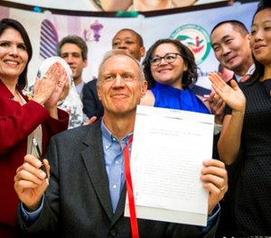 Illinois Gov. Bruce Rauner smiles while surrounded by law enforcement officials and immigrant rights activists in Chicago's Pilsen neighborhood Monday, Aug. 28, 2017, after signing legislation that will limit how local and state police can cooperate with federal immigration authorities.