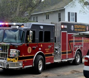 A Stafford firefighter was injured after falling down a 20-foot slope while battling a four-acre brush fire that threatened apartments on Tuesday.