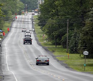 Law enforcement officers stand along Route 374 as the search for prison escapees David Sweat and Richard Matt continues