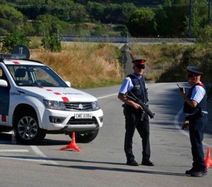 Armed police officers stand guard near Subirats, Spain, Monday, Aug. 21, 2017. A police operation was underway Monday in an area west of Barcelona, and a Spanish newspaper reports that the fugitive in the city's van attack has been captured. Regional police said officers shot a man wearing a possible explosives belt in Subirats, a small town 45 kilometers (28 miles) west of Barcelona. (AP Photo/Emilio Morenatti)