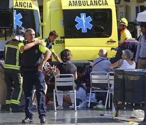 Injured people are treated in Barcelona, Spain, Thursday, Aug. 17, 2017 after a white van jumped the sidewalk in the historic Las Ramblas district.