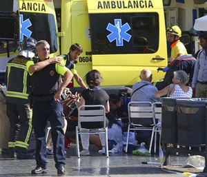 Injured people are treated in Barcelona, Spain, Thursday, Aug. 17, 2017 after a white van jumped the sidewalk in the historic Las Ramblas district.