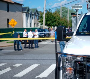 New York City Police officials gather along Wilcox Street behind the 121st Precinct station house following a report of a police officer shot in the Staten Island borough of New York. (Joseph Ostapiuk/Staten Island Advance via AP)