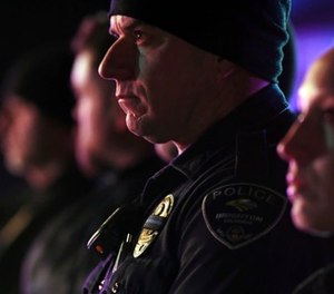 Brighton police officers wear a black ribbon over their badge for Adams County Sheriff's Deputy Heath Gumm in Brighton, Colo., Thursday, Jan. 25, 2018. (John Leyba/The Denver Post via AP)