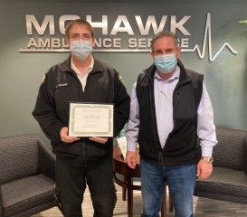 Mohawk Ambulance Service EMT Jesse Strader (left), who is also a volunteer firefighter with the Rexford Fire Department, is presented a Heroism Award by Mohawk Ambulance Service President James P. McPartlon III.