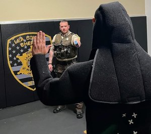 Corporal Kyle Blakely demonstrates a training scenario where he uses his support hand to draw his TASER from his custom load-bearing vest.