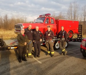 A small group from the Danbury (Connecticut) Fire Department poses with a replica truck from the hit TV show 