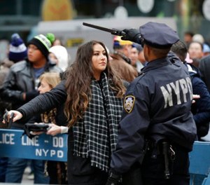 In this Dec. 31, 2015 file photo, pedestrians submit to a search as they enter Times Square in New York. (AP Photo/Seth Wenig, File)