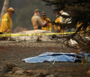 A bag containing human remains lies on the ground as officials continue to search at a burned out home at the Camp Fire. (Photo/AP)
