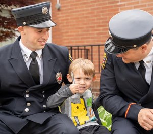 Canton Firefighter/ Paramedic Benjamin Lasure (left) was honored for saving 7-year-old Colton Grewell (middle) from a house fire on May 6. (Photo/Canton City Fire Department)