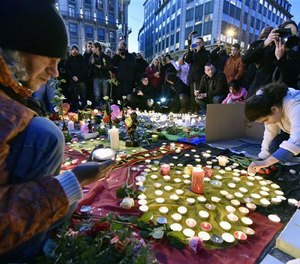 People bring flowers and candles to mourn for the victims at Place de la Bourse in the center of Brussels, Tuesday, March 22, 2016.