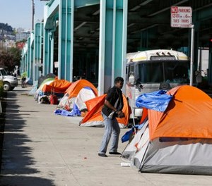In this Feb. 23, 2016 file photo, a man stands outside of his tent on Division Street in San Francisco.